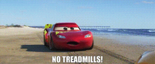 A Red Car Is Driving On A Beach With The Words `` No Treadmills '' Written On It . GIF