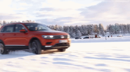 A Red Car Is Driving On A Snowy Road With A License Plate That Says ' Tdi ' On It GIF