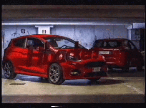 A Red Car Is Parked In A Garage With The Number 11 On The Wall Behind It GIF