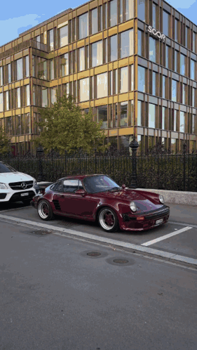 A Red Car Is Parked In Front Of A Building That Says Scorp GIF