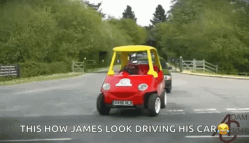 A Red Car With A Yellow Top Is Driving Down A Road With The Caption This How James Look Driving His Car GIF