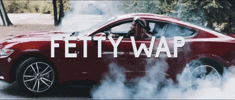 A Red Car With Smoke Coming Out Of It And The Words Fetty Wap GIF