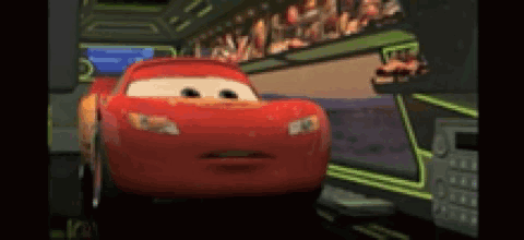 A Red Cartoon Car From The Movie Cars Is Driving Down A Road . GIF