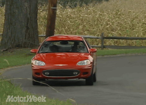 A Red Chrysler Car Driving Down A Road GIF