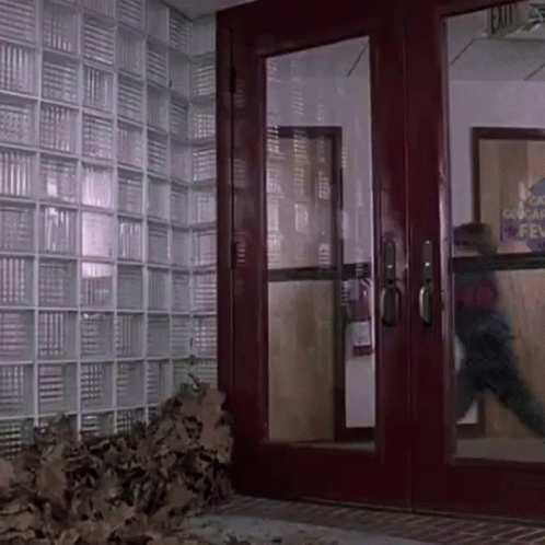A Red Door With A Sign That Says Exit GIF