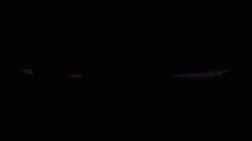 A Red Eye And A Purple Eye Are Glowing In The Dark On A Black Background . GIF