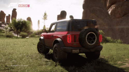 A Red Ford Bronco Is Parked In A Grassy Field With Horizon 5 Written On The Screen GIF