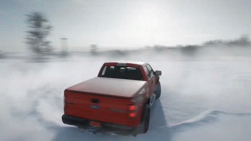 A Red Ford Truck Driving Through The Snow GIF