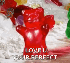A Red Gummy Bear Is Sitting On Top Of A Pile Of Gummy Bears . GIF