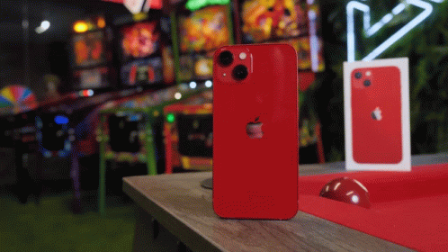 A Red Iphone Is Sitting On A Table In Front Of An Arcade GIF
