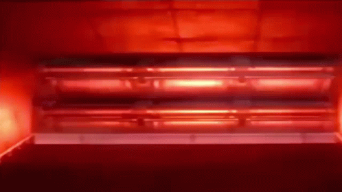 A Red Light Is Coming Out Of A Red Oven . GIF