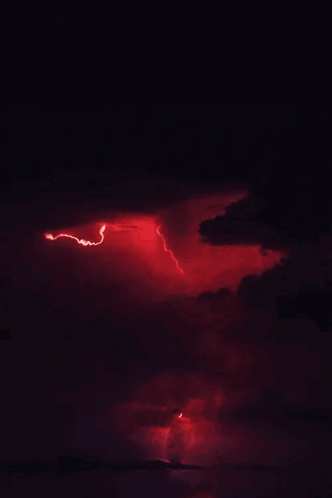 A Red Lightning Bolt Strikes Through The Clouds In The Night Sky GIF