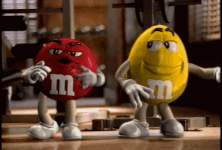 A Red M & M And A Yellow M & M Are Standing Next To Each Other In A Gym GIF