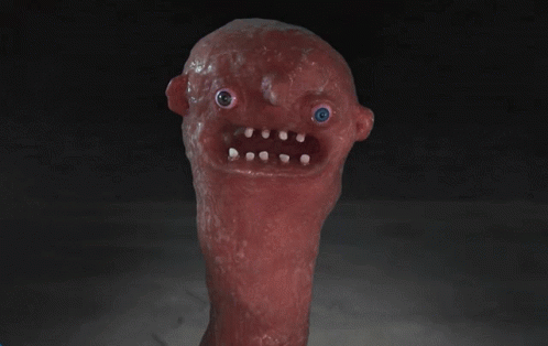A Red Monster With A Blue Eye And White Teeth Is Looking At The Camera GIF