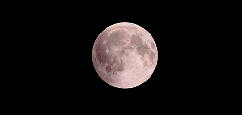 A Red Moon Is Visible In The Dark Sky GIF