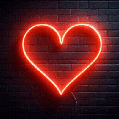 A Red Neon Heart Is Lit Up On A Dark Brick Wall GIF