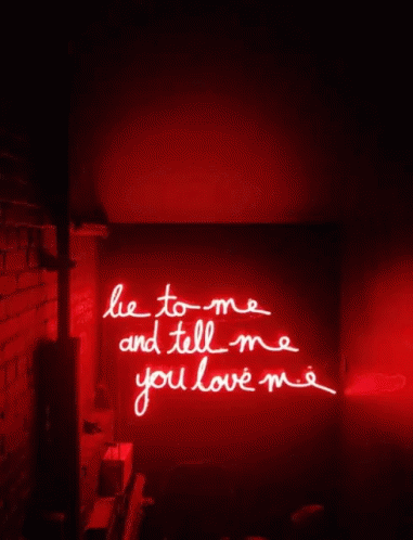 A Red Neon Sign Says Lie To Me And Tell Me You Love Me GIF