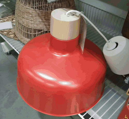 a red pendant light with a wooden top