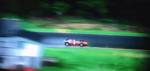 A Red Race Car With The Number 1 On The Side Is Driving Down A Track GIF