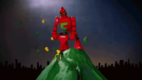 A Red Robot Is Standing On Top Of A Green Hill With The Words Frederator Studios Above Him GIF