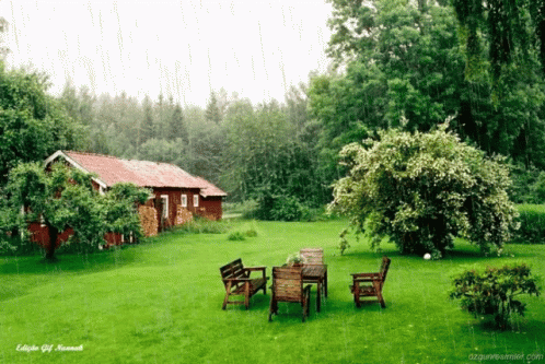 A Red Shed Sits In The Middle Of A Green Field GIF