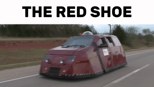A Red Shoe Van Is Driving Down A Road . GIF