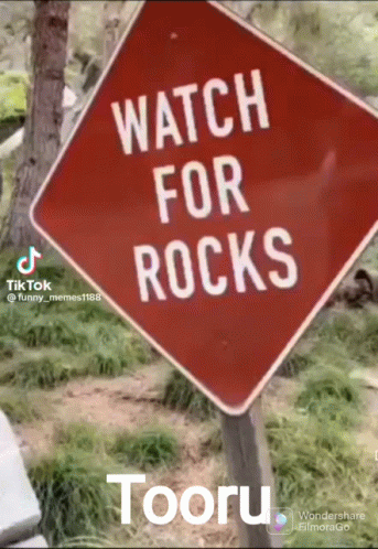 A Red Sign That Says " Watch For Rocks " On It GIF