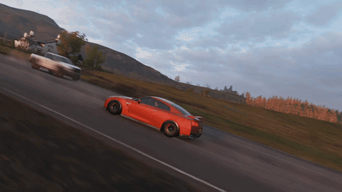 A Red Sports Car Is Driving Down A Road GIF