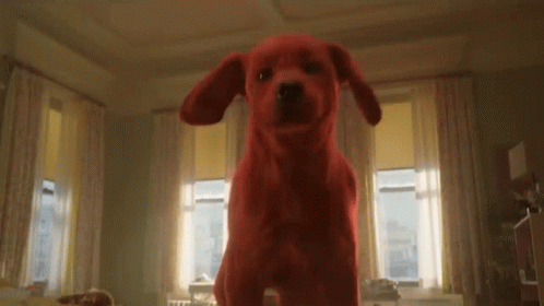 A Red Stuffed Dog Is Standing In A Living Room . GIF