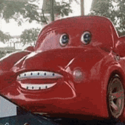 A Red Toy Car With Big Eyes And A Smile On Its Face GIF
