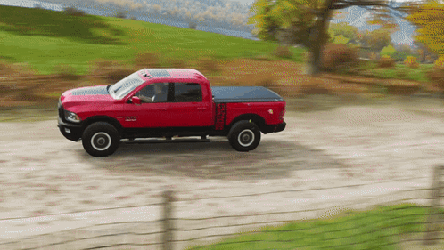 A Red Truck Is Driving Down A Dirt Road GIF