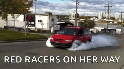 A Red Van Is Driving Down A Street With The Words Red Racers On Her Way GIF