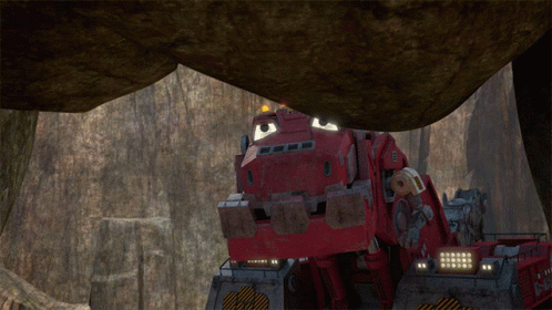 A Red Vehicle Is Driving Through A Rocky Area GIF