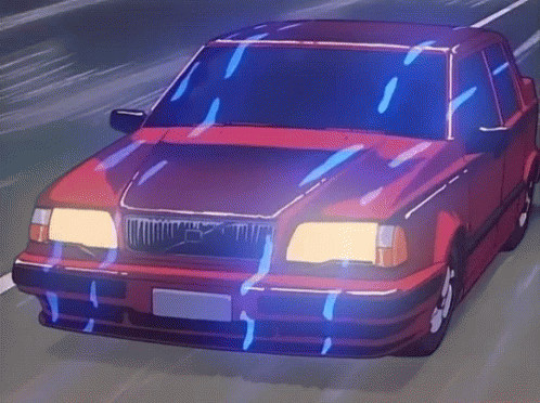 A Red Volvo Is Driving Down A Road At Night GIF