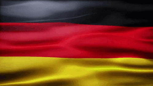 A Red Yellow And Black Flag Is Waving In The Wind GIF