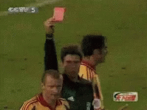 A Referee Holds Up A Red Card In Front Of A Player Wearing A Yellow Jersey With The Number 22 On It GIF