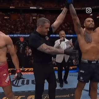 A Referee Holds Up A Shirtless Fighter 'S Arm In A Boxing Ring GIF