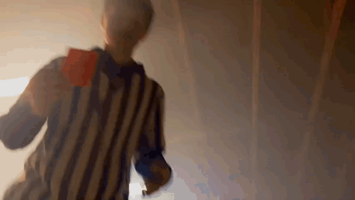 A Referee In A Striped Shirt Is Holding A Red Card In His Hand . GIF