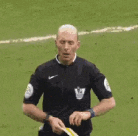 A Referee Is Giving A Yellow Card To A Soccer Player On A Field . GIF