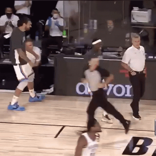 A Referee Is Running Towards A Basketball Player On A Court During A Game . GIF
