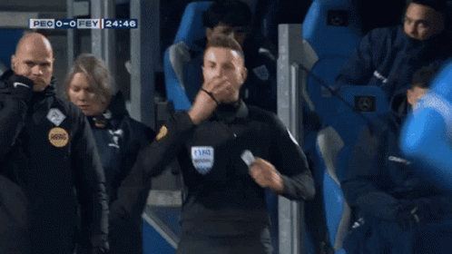 A Referee Is Standing In Front Of A Crowd During A Soccer Game GIF