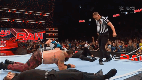 A Referee Is Standing In Front Of A Raw Sign GIF