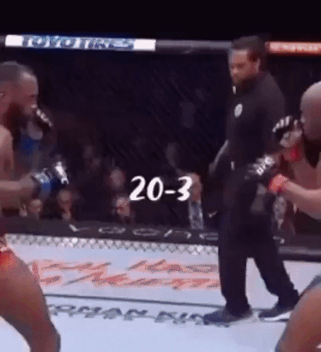A Referee Is Standing In The Middle Of A Boxing Match With The Number 20-3 Written On The Screen . GIF