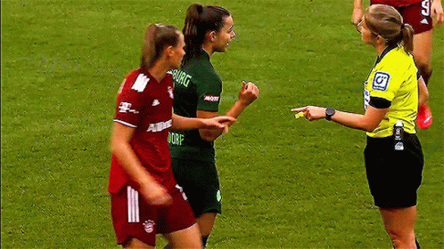 A Referee Is Talking To Two Female Soccer Players One Of Whom Is Wearing A Shirt That Says Dorf GIF