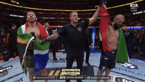 A Referee Stands Between Two Fighters During A Ufc Fight GIF