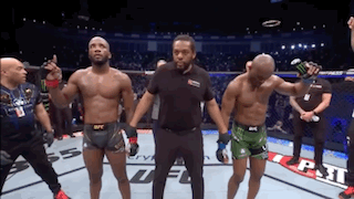 A Referee Stands Between Two Fighters In A Boxing Ring GIF