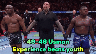A Referee Stands Between Two Fighters With The Words 49-46 Usman Experience Beats Youth Below Him GIF