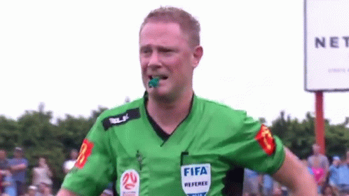 A Referee Wearing A Green Shirt With The Word Fifa On It . GIF