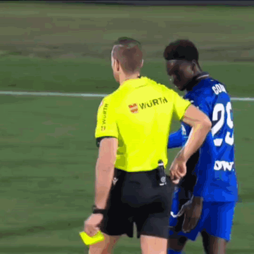 a referee wearing a yellow shirt that says wurth