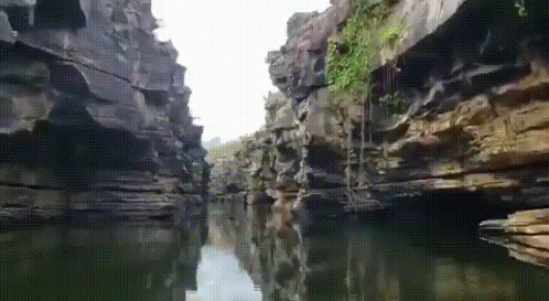 A River Runs Through A Narrow Canyon Surrounded By Cliffs GIF